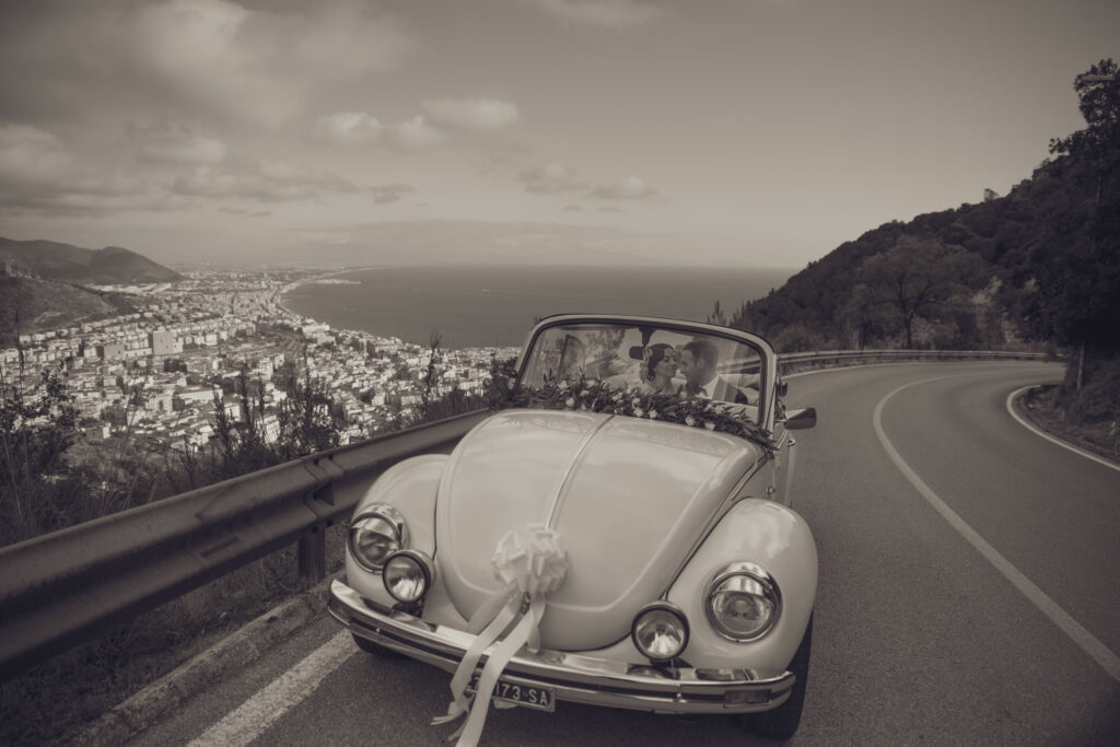 Immagine di sposi su un vecchio maggiolino scattata da Fotografo per cerimonie a Salerno